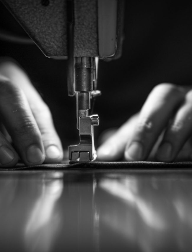a man at work on a sewing machine. without a face.