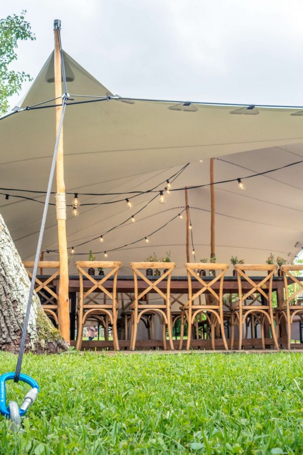 Image of huge white tent for a wedding event in the nature with green grass